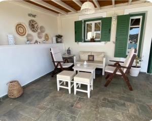 a patio with a table and chairs and green shutters at Luxury Maisonet Veranda View Batsi in Batsi