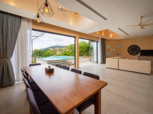 a dining room with a table and a large window at Teetara Villa Patong in Patong Beach