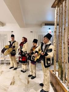 Eine Gruppe uniformierter Männer, die in einem Raum Instrumente spielen in der Unterkunft Pensiunea ROCA Maramures in Deseşti