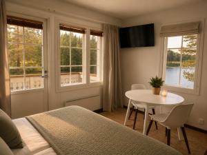 a bedroom with a bed and a table and windows at Aldeia Bianca Lake Resort & Italian Restaurant in Kerimäki
