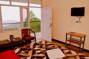 a room with a bed and a desk and a window at Hotel Annapurna in Dharamshala