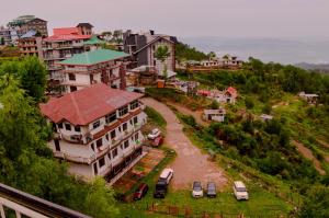 an aerial view of a town with cars parked on a hill at Hotel Annapurna in Dharamshala