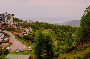 an aerial view of a village with cars parked on a hill at Hotel Annapurna in Dharamshala +21 photos