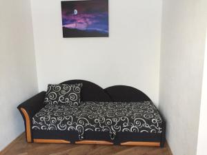 a bed with a black and white bedspread and a pillow at Klaipedas 108 Street Apartment in Liepāja