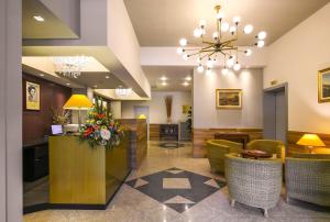 a lobby of a hotel with a reception desk and chairs at Hotel Falco D'Oro by Falco D'Oro Hotels in Tolè