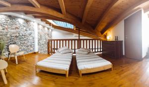 two beds in a room with a stone wall at PICCOLA VILLA nel Centro Storico in Arona