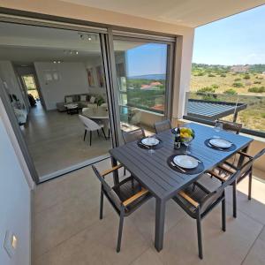 a dining table and chairs in a room with a view at Premium Šimuni by Pag tours in Šimuni