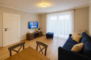 a living room with a blue couch and a table at Apartament 1go Maja TK in Namysłów