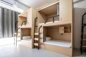 two bunk beds in a room with a window at Passerby hostel samui in Nathon Bay