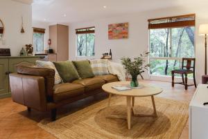 a living room with a couch and a table at River Reach Chalet - Cosy Forest Hideaway in Margaret River Town