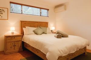 a bedroom with a large bed and a window at River Reach Chalet - Cosy Forest Hideaway in Margaret River Town