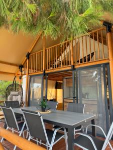 a patio with a table and chairs and a balcony at Luna Glamping de Luxe in Drage