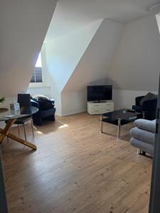 a living room with a couch and a tv at Gemütliche Ferienwohung in Neubrandenburg