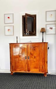 a wooden cabinet with a mirror on a wall at Mosel-Studio-Apartment in Lieser
