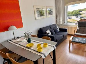 a living room with a table and a couch at De Strandloper in Julianadorp