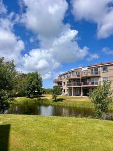 an apartment building next to a body of water at De Strandloper in Julianadorp