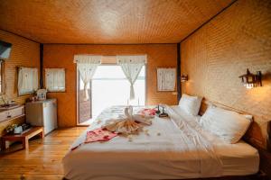 a bedroom with a large white bed with a window at Phupai Lake Resort in Ban Wang Khun Knachen