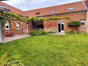 a brick building with a lawn in front of it at La Clé des Vignes 3 in Roye