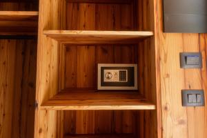 ein Holzregal mit einer Mikrowelle in einer Sauna in der Unterkunft Malga Prefaè in Commezzadura