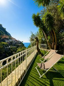 a chair sitting on the grass next to a fence at Il Canneto in Positano