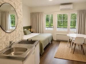 a bedroom with a bed with a sink and a mirror at Aldeia Bianca Lake Resort & Italian Restaurant in Kerimäki