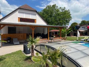 a house with a car parked next to a swimming pool at Nice Big House in Balatonfenyves