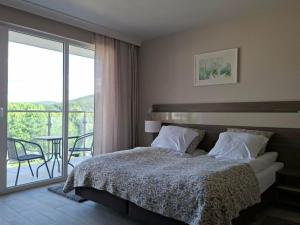a bedroom with a bed and a balcony with a table at Apartament Bormio MarsMed in Biała Woda