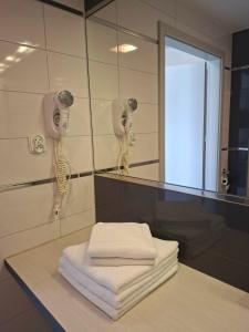 a bathroom with a mirror and a pile of towels at Apartament Bormio MarsMed in Biała Woda