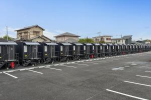 a long line of train cars parked in a parking lot at HOTEL R9 The Yard Kurate in Nakama