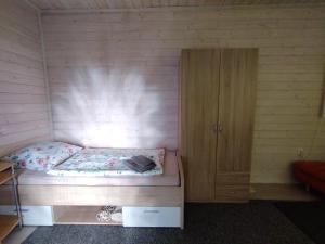 a small bedroom with a bed and a wooden cabinet at Rekreační chatka / Tiny House in Františkovy Lázně