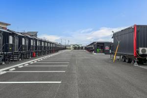 a row of train cars parked in a parking lot at HOTEL R9 The Yard Kurate in Nakama +16 photos