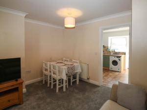 a dining room with a table and chairs and a tv at Flat 1 in Newton Abbot