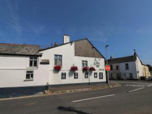a white building on a street with a stop sign at Flat 1 in Newton Abbot