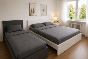 a bedroom with two beds and two windows at Pulheim Living 3 in Pulheim