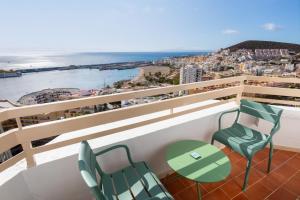 a balcony with chairs and a table and a view of the ocean at SOL by Meliá Arona Tenerife in Los Cristianos +55 photos