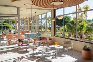 a restaurant with chairs and tables and windows at SOL by Meliá Arona Tenerife in Los Cristianos