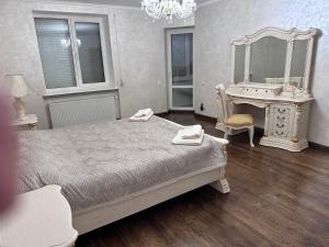 a bedroom with a bed and a dressing table and a mirror at Оксамитове ретро in Ternopil