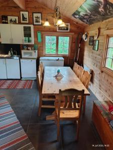 a kitchen and dining room with a wooden table and chairs at Reisa River Lodge in Potka