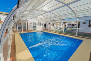 an indoor swimming pool with an expandable roof at Rivero Rural Casa Rural para Grupos y Familias en Córdoba in Posadas