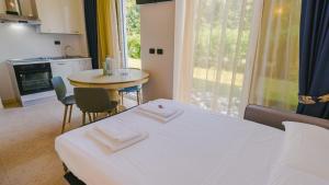 a room with two beds and a table and a window at Residence Relais du Lac Village & Elite in Desenzano del Garda