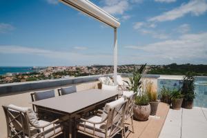 a patio with a table and chairs on a balcony at APPARTEMENT PISCINE TERRASSE 1 MIN PLAGE et GOLF in Bidart