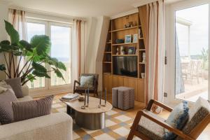 a living room with a couch and a table at APPARTEMENT PISCINE TERRASSE 1 MIN PLAGE et GOLF in Bidart