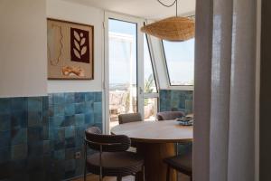 a dining room with a table and chairs and a window at APPARTEMENT PISCINE TERRASSE 1 MIN PLAGE et GOLF in Bidart