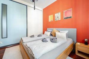 a bed in a room with an orange wall at EDLER WOHNRAUM Design-Loft im Graphischen Viertel 2 Schlafzimmer mit Balkon, Miele-Kaffeevollautomat, Miele-Weinkühler, Klima, Lift, Tiefgarage & WLAN 266 Mbps in Leipzig