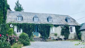 a house covered in ivy with a green door at Venez Dormir chez Nous Dans Les BaRoNNieS ! Dans notre Caravane CARavelaiR 1979 in Labastide