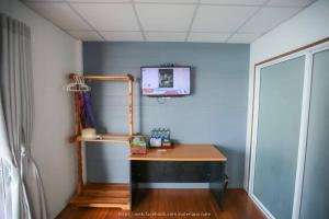 a room with a desk and a tv on a wall at Phupai Lake Resort in Ban Wang Khun Knachen