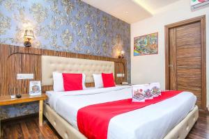 a hotel room with two beds with red pillows at Hotel O TAJ STARS in Zirakpur +17 photos
