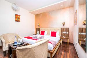 a hotel room with a bed and a table and chairs at Hotel O TAJ STARS in Zirakpur
