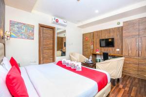 a hotel room with a bed and a desk and a television at Hotel O TAJ STARS in Zirakpur
