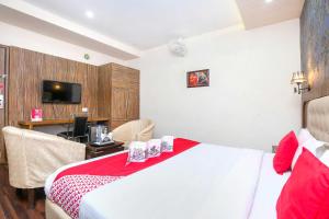 a hotel room with a bed and a desk and a television at Hotel O TAJ STARS in Zirakpur